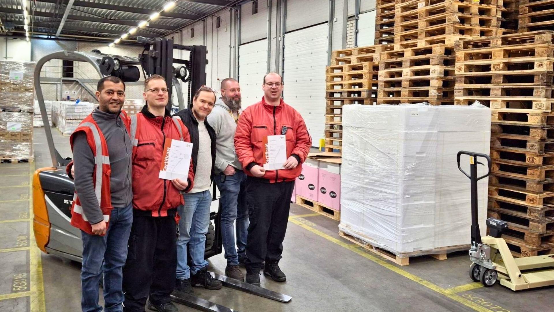 Vijf medewerkers van het magazijn bij een heftruck